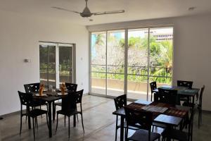 a dining room with tables and chairs and a large window at The Big House in Colombo
