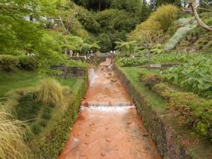 a stream of water in a garden with trees at Aparthotel Barracuda in Ponta Delgada