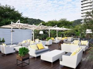 a patio with white chairs and umbrellas at Calendar Hotel in Otsu