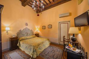 a bedroom with a bed and a flat screen tv at B&B Piccolo Hotel in Cortona