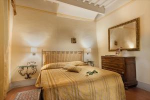 sypialnia z łóżkiem, komodą i lustrem w obiekcie B&B Piccolo Hotel w mieście Cortona