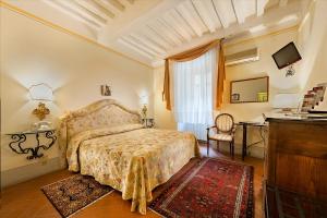 a bedroom with a bed and a table and a tv at B&B Piccolo Hotel in Cortona