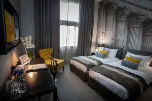 a hotel room with two beds and a table at Grey Street Hotel in Newcastle upon Tyne