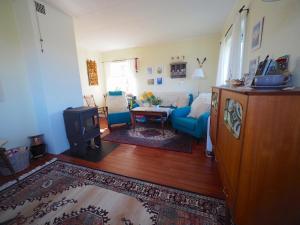 - un salon avec un canapé bleu et une table dans l'établissement Steinbakk - Vestresand Lofoten, à Bøstad