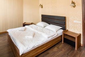 リヴィウにあるLEOGRAND Apartments on Doroshenka Street 1のベッドルーム(白いシーツを使用した大型ベッド1台付)