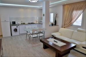 a living room with a couch and a table at Royal Lea Apartmens in Netanya