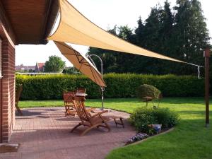 a patio with two chairs and an umbrella at Carolines Gästezimmer in Meppen