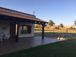 eine Terrasse eines Hauses mit einem Tisch und Stühlen in der Unterkunft Los Abetos in Abay