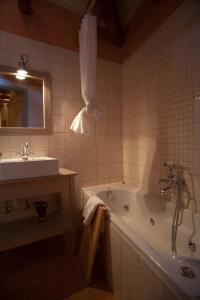 ein Badezimmer mit einer Badewanne und einem Waschbecken in der Unterkunft Astra Inn in Papigko