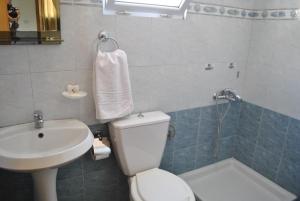 a bathroom with a white toilet and a sink at Eden Hotel in Gjirokastër