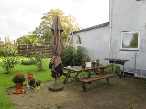 - une terrasse avec une table de pique-nique et un parasol dans l'établissement Hos Tina, à Roskilde