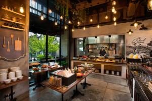 a restaurant with a counter with food on it at Somerset Ekamai Bangkok in Bangkok