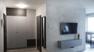 salon z telewizorem na ścianie w obiekcie Art Apartments we Wrocławiu