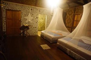 a room with two beds and a table in it at Khao Sok Green Mountain View in Khao Sok National Park