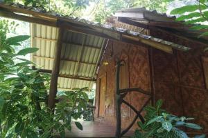 an outside view of a small house with a wooden porch at Khao Sok Green Mountain View in Khao Sok National Park