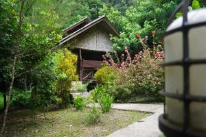 a garden with a bench in front of a house at Khao Sok Green Mountain View in Khao Sok National Park