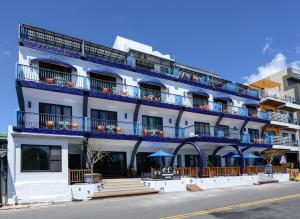 un edificio bianco con balconi blu su una strada di Kenting Coast Resort a Kenting Altre 37 foto