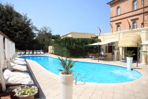 a swimming pool with lounge chairs next to a building at Villa Adriatica Ambienthotels in Rimini