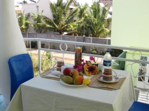 a table with a plate of fruit on a balcony at Villa Kissen in Trou aux Biches