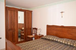 1 dormitorio con 1 cama y 1 cruz en la pared en La Stella Del Pollino, en San Lorenzo Bellizzi