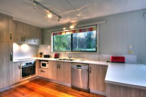 cocina con fregadero y ventana en Cove Beach Apartment 2, en Coles Bay