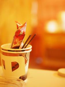a coffee cup with chopsticks in it on a table at Chanta Boutique Place in Ubon Ratchathani
