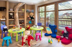 a childs room with tables and chairs and teddy bears at Hôtel Les Barmes De l'Ours in Val dʼIsère