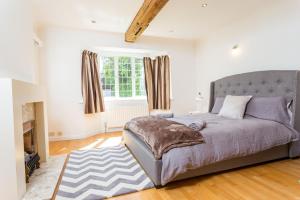 een slaapkamer met een groot bed en een raam bij The Queen Edith Place - Lovely 6BDR Home in Secluded Area in Cambridge