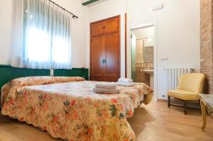 Un dormitorio con una cama y una silla y una ventana. en Villamilagro, en Sueca 17 fotos más
