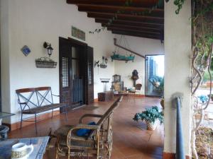 een woonkamer met stoelen en een tafel in een huis bij Villa Amalia - mansarda in Cinisi
