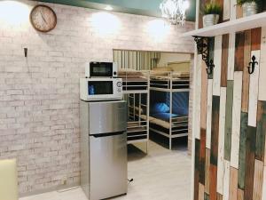 a kitchen with a microwave on top of a refrigerator at Guest House Fukuoka W001 in Kasuga