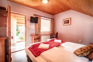 a bedroom with a bed with a red towel on it at Ópusztaszeri Erdei Wellness Vendégház in Ópusztaszer +44 photos