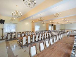 uma grande sala com mesas e cadeiras e lustres em Bumerang em Nowa Biała