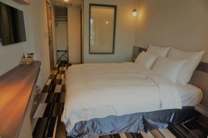 Postel nebo postele na pokoji v ubytování Watermark Hotel Kaohsiung Main Station