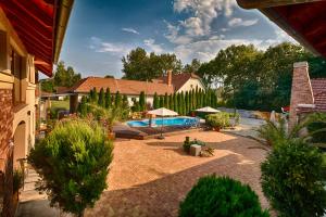 a backyard with a swimming pool and a house at Ópusztaszeri Erdei Wellness Vendégház in Ópusztaszer