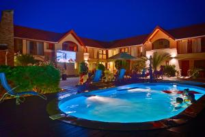a swimming pool in the backyard of a house at night at Ópusztaszeri Erdei Wellness Vendégház in Ópusztaszer