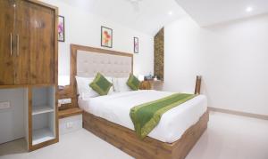 a bedroom with a large bed with white sheets and green pillows at Treebo Trend Amber International in Mumbai
