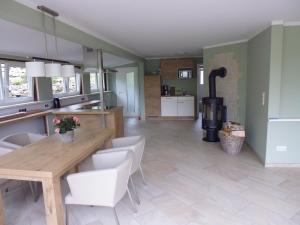 a kitchen with a table and chairs and a fireplace at Bungalow A in Börnecke