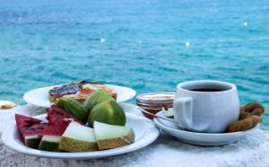 a table with two plates of food and a cup of coffee at Psili Ammos in Mylopotas