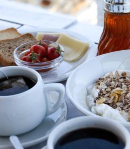 a table with plates of food and a cup of coffee at Psili Ammos in Mylopotas +33 photos
