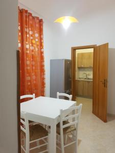 einen weißen Tisch und Stühle in einem Zimmer mit Küche in der Unterkunft Alla casa di Anna in Trapani