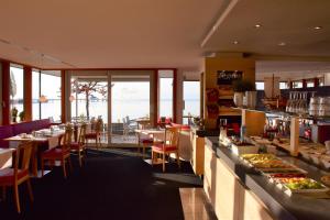 a restaurant with tables and chairs with a view of the ocean at Strandhaus Eberle in Immenstaad am Bodensee