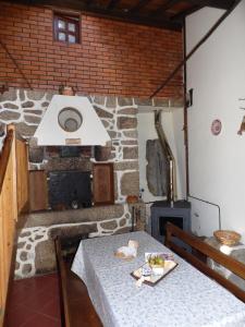 a dining room with a table and a fireplace at Casa do Forno in Valezim