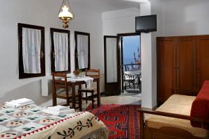 a bedroom with a bed and a table and a dining room at Archontiko Elda in Agios Dimitrios