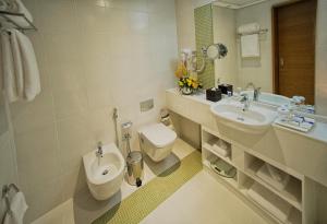 a bathroom with a toilet and a sink at TRYP by Wyndham Abu Dhabi City Center in Abu Dhabi
