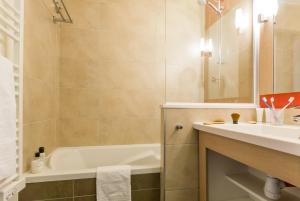 a bathroom with a tub and a sink and a bath tub at Résidence Pierre & Vacances Atria-Crozats in Avoriaz +37 photos