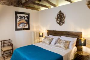 a bedroom with a large bed with a blue blanket at L'8 Boutique Concept Apartments in Bologna