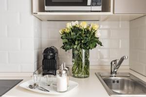 a vase of flowers sitting on a kitchen counter at L'8 Boutique Concept Apartments in Bologna +106 photos