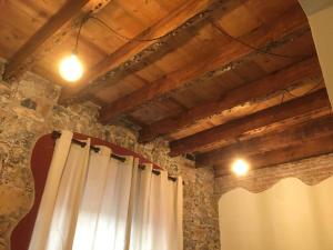 um quarto com uma cortina e uma parede de pedra em La Taverna del Metallo Rooms em La Spezia