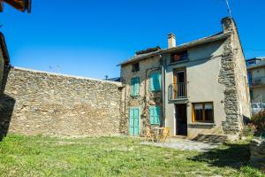 オセジャにあるla Cabaña de la Foretの緑のドアとバルコニーが備わる古い石造りの家